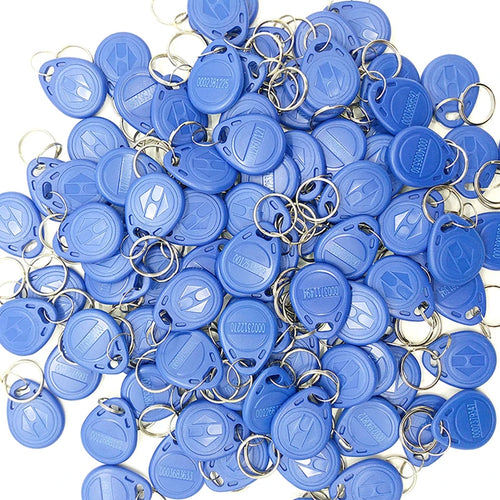 A pile of blue plastic RFID key fobs, each with a metal split ring and an embossed logo.