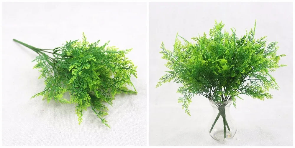 Artificial fern branches with vibrant green, feathery leaves, shown lying down and arranged in a clear glass vase.
