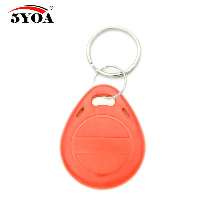 Orange plastic RFID key fob with a metal ring, teardrop shape, and embossed horizontal line detail.