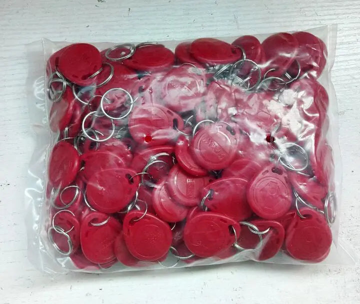 Bulk bag of red plastic RFID proximity key fob tags with silver metal key rings.
