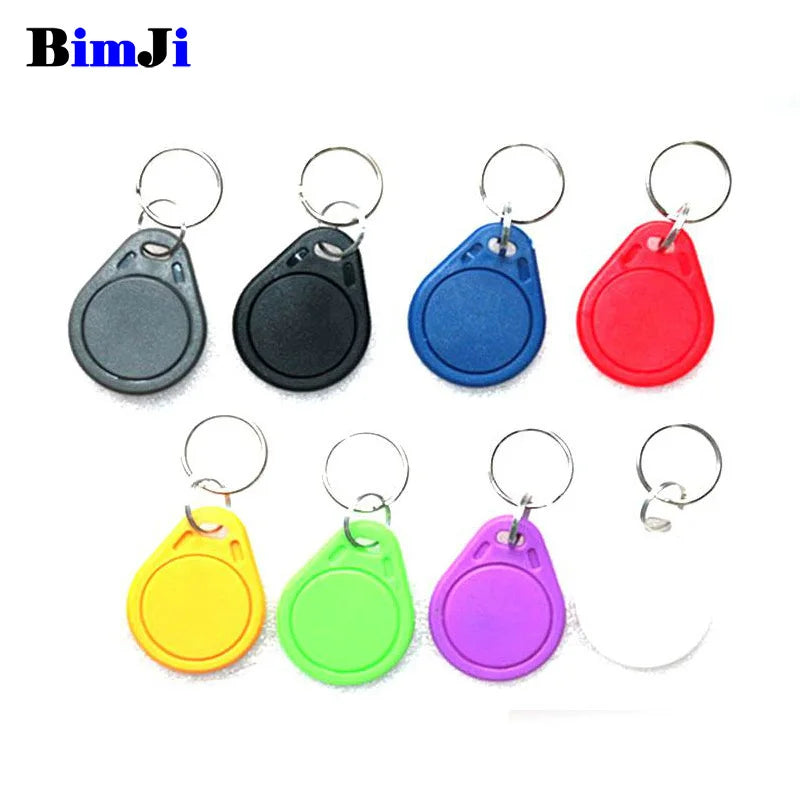 Eight colorful plastic RFID key fob tags with metal rings, arranged in two rows against a white background.