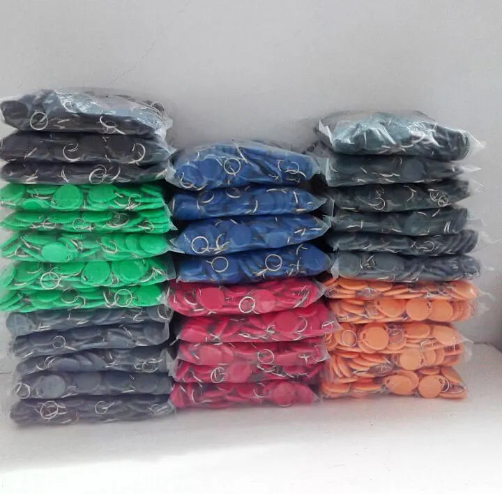 Stacks of bags containing multi-colored plastic circular key tags with metal key rings.
