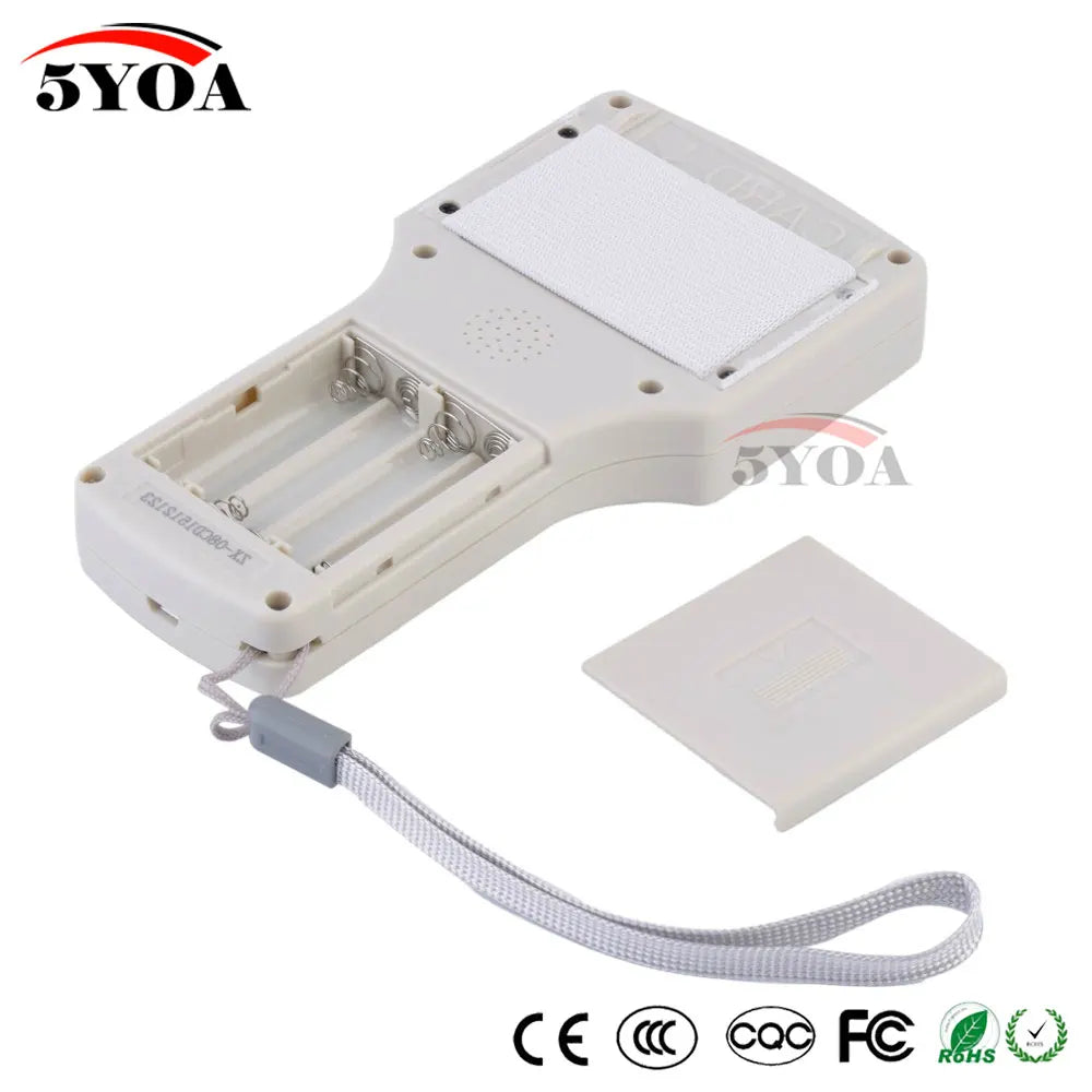 Off-white plastic handheld device with open battery compartment, white fabric patch, and a grey wrist strap.