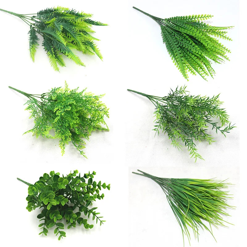 Six varieties of artificial green plastic plant sprigs, including ferns, grasses, and eucalyptus leaves.