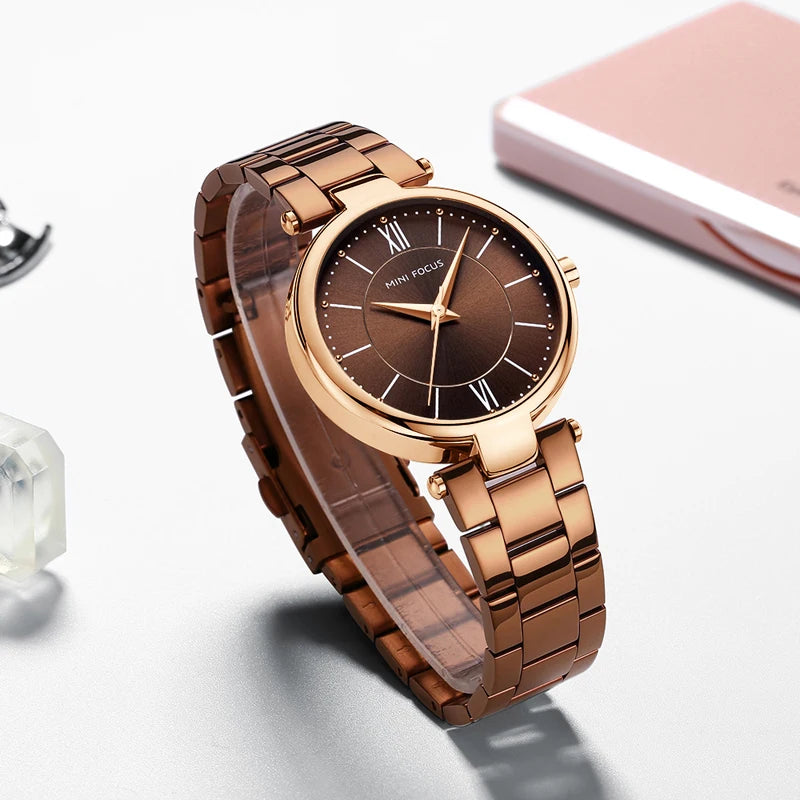 Mini Focus coffee brown quartz watch with round case, matching stainless steel strap, and minimal dial.