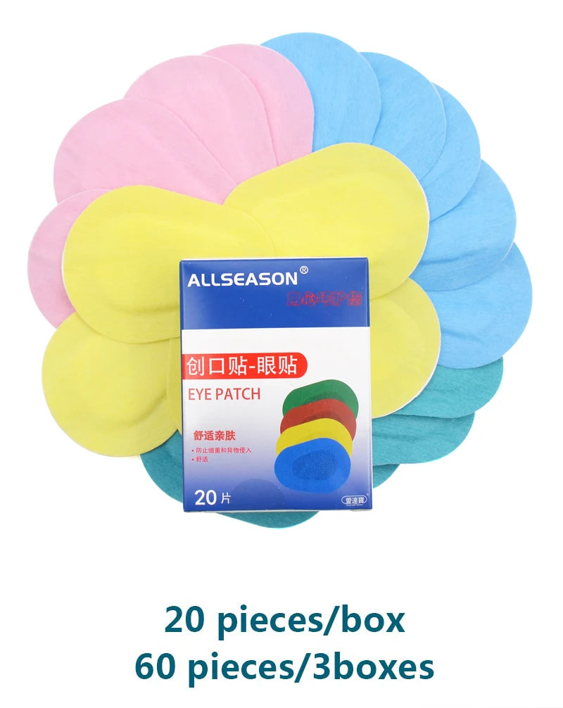 A box of 20 assorted multi-colored fabric eye patches in pink, yellow, blue, and green for medical use.