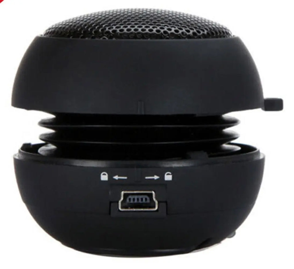 Compact black burger-style portable speaker with an expandable design and USB charging port.