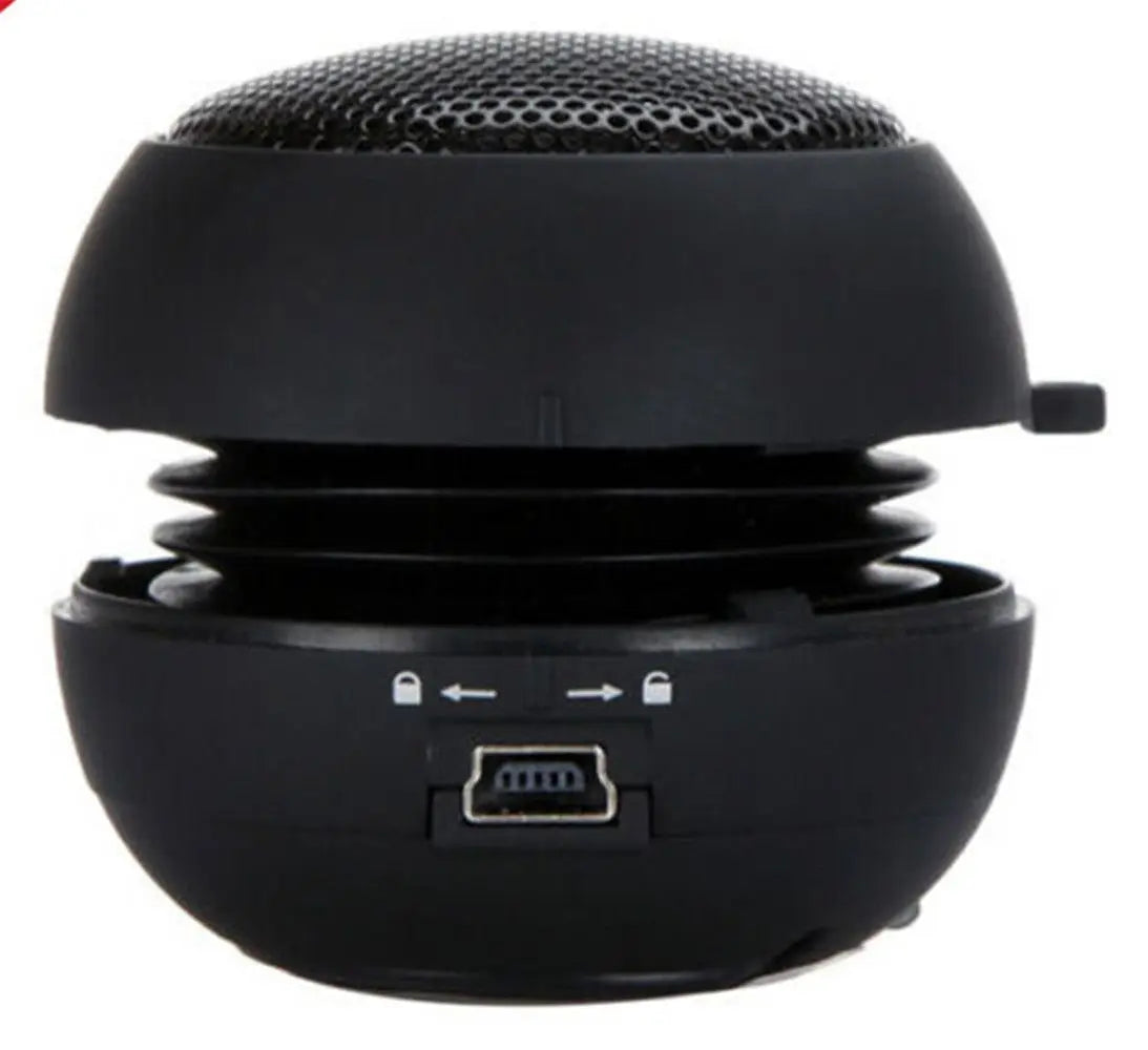 Compact black burger-style portable speaker with an expandable design and USB charging port.