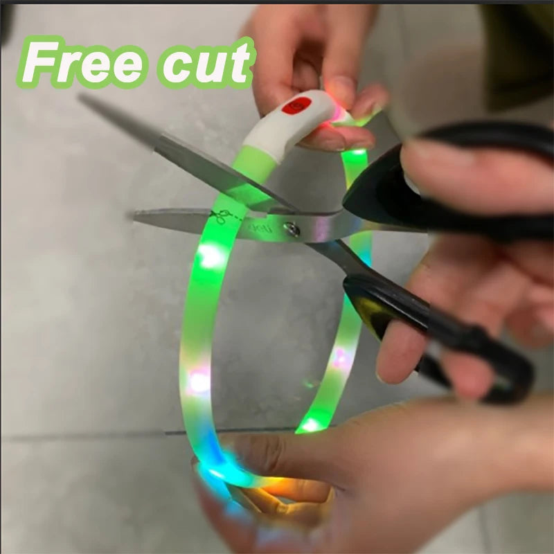 Green silicone LED dog collar being cut with scissors to adjust size, featuring bright lights and a power module.