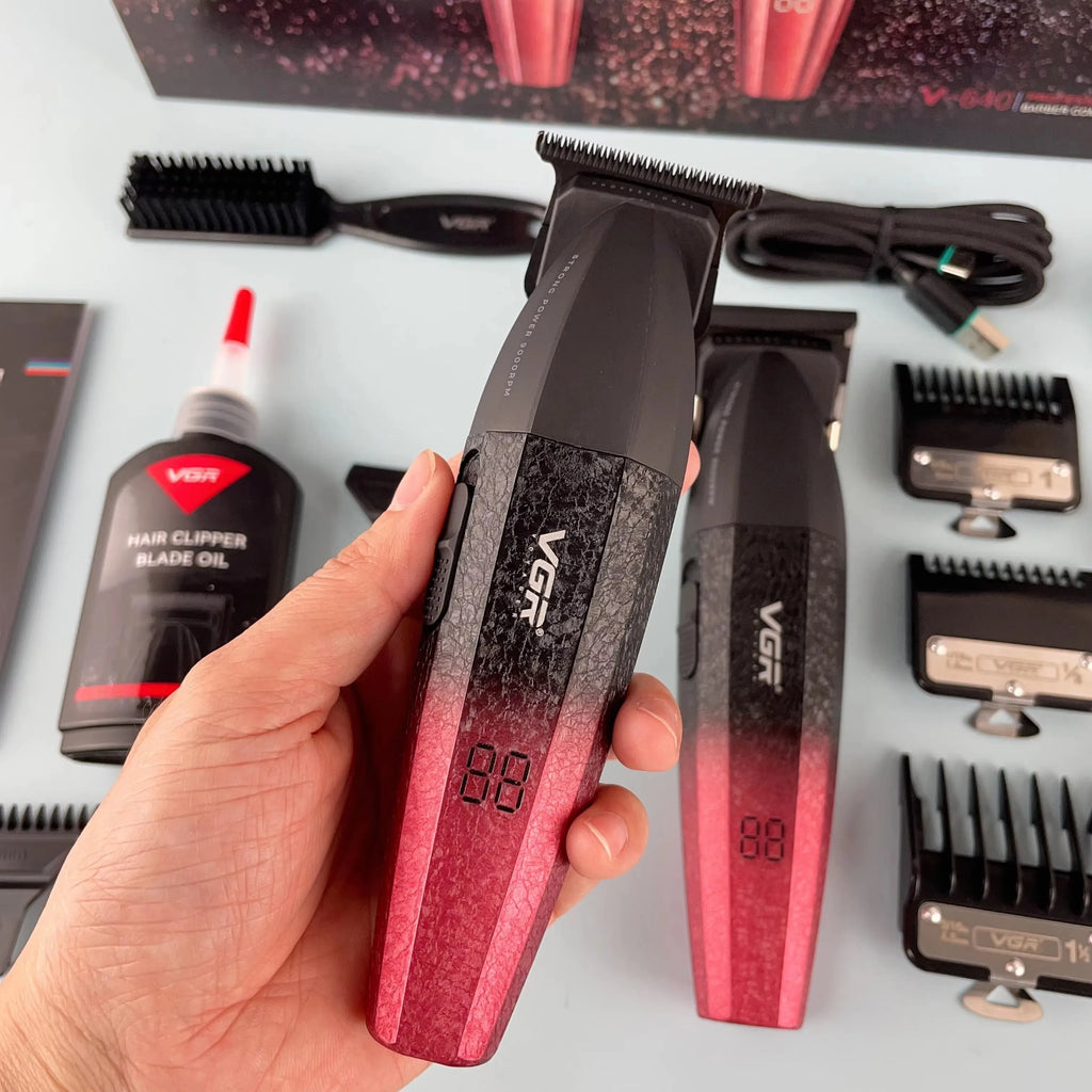 A professional cordless hair and beard trimmer in a black-to-red ombre finish with a digital LED battery display.
