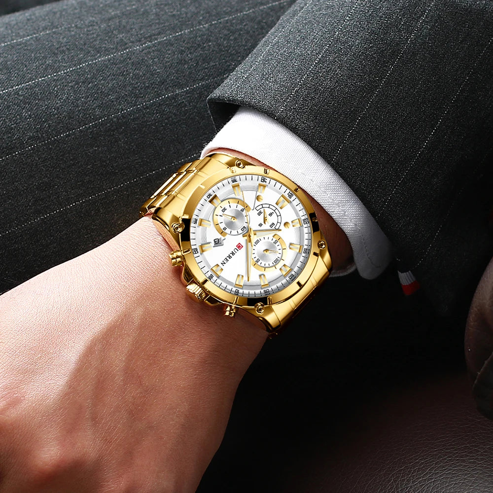 A man wearing a gold-tone stainless steel luxury business watch with a white dial, chronograph sub-dials and date.