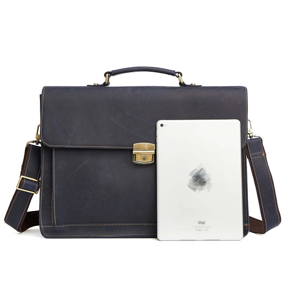 Dark navy blue genuine leather briefcase with a brass clasp, top handle, and adjustable shoulder strap.