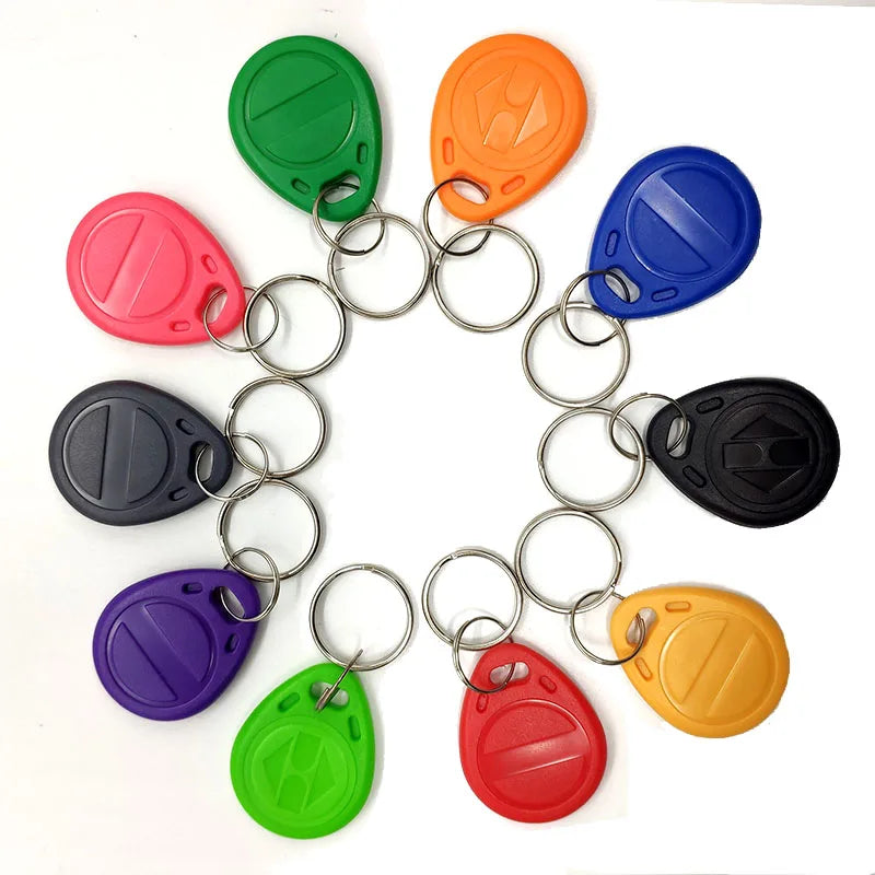 Ten multi-coloured plastic RFID key fob tags with metal split rings, arranged in a circle on a white background.