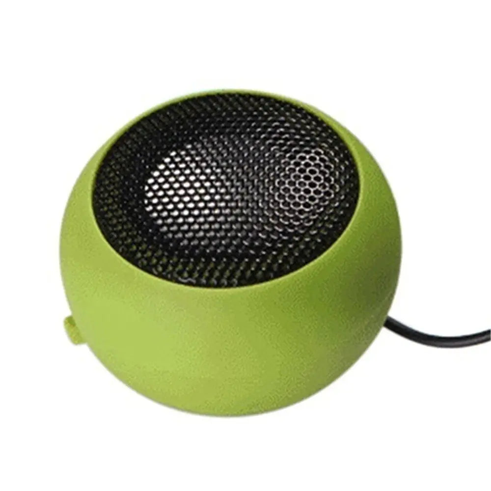 Small, lime green spherical portable speaker with a black metal mesh front grill and integrated power cable.