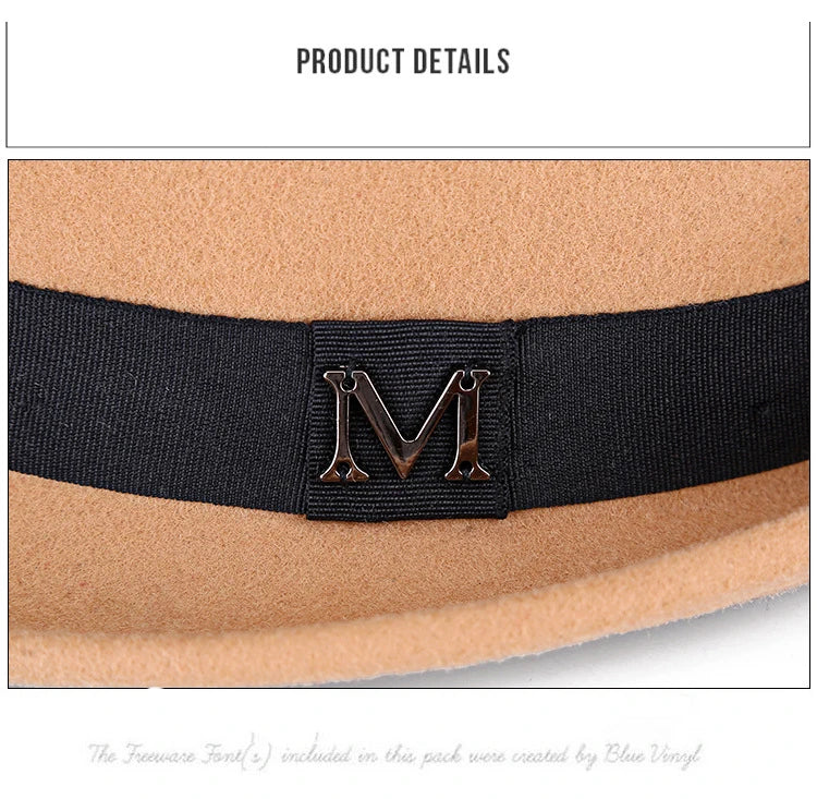 Close-up of a tan wool felt fedora featuring a black ribbed ribbon band with a metallic 'M' emblem.