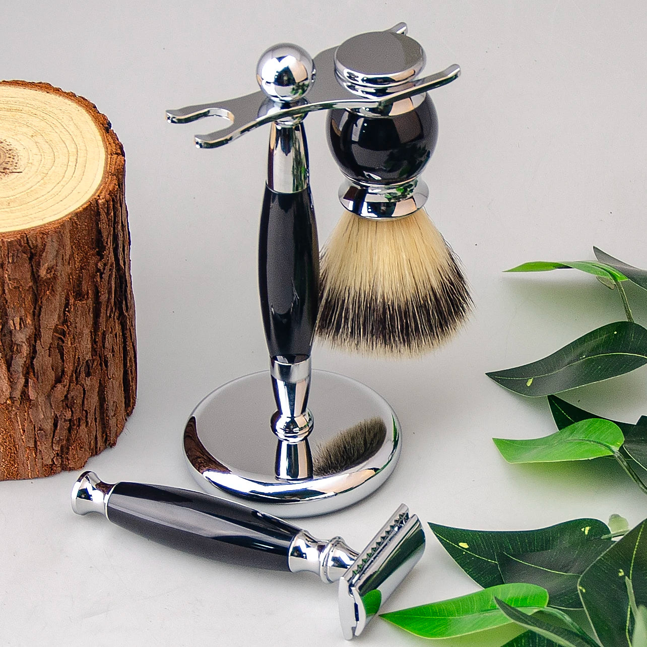 Luxury wet shaving kit featuring a chrome and black handle safety razor, shaving brush, and a matching chrome stand.