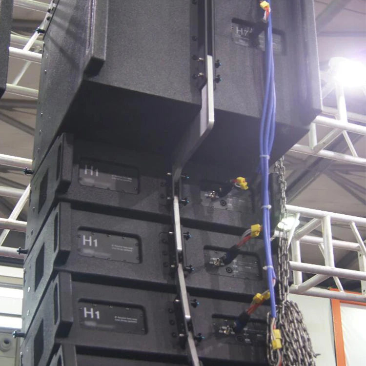 A stack of black, professional-grade, high-power full-range stage speakers suspended on a metal rig.