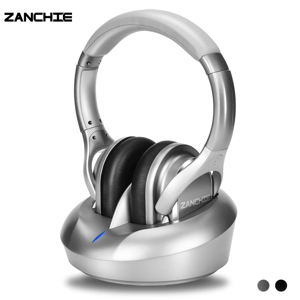 Silver wireless TV headphones with black cushioned ear pads, sitting on a matching silver charging transmitter base.