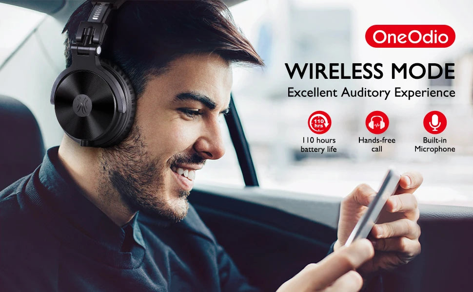 Man wearing black wireless over-ear headphones with a built-in microphone while using a smartphone in a car.