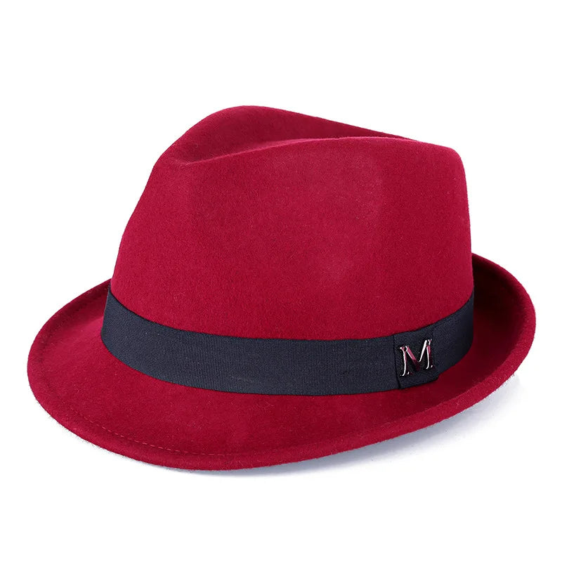 A classic red wool felt fedora hat with a black ribbon band and a small silver ‘M’ detail.