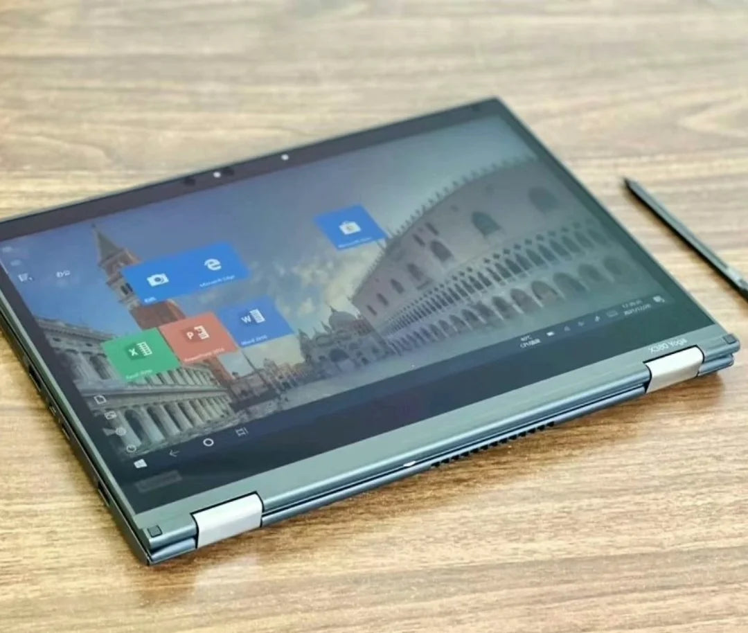 Sleek charcoal grey 13.3-inch 2-in-1 touchscreen business laptop folded flat, including a stylus on a wooden desk.