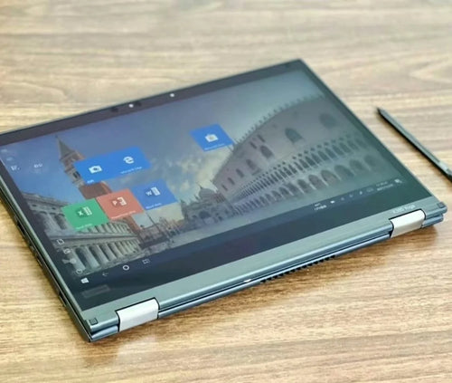 Sleek charcoal grey 13.3-inch 2-in-1 touchscreen business laptop folded flat, including a stylus on a wooden desk.