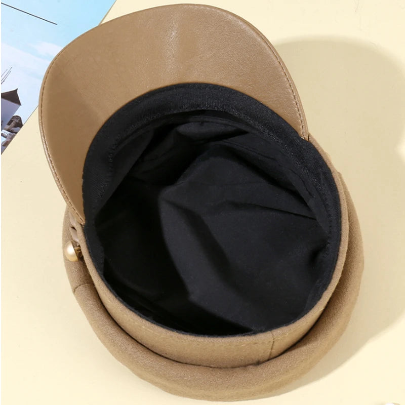 Camel-coloured felt military-style cap with a black interior lining and a side gold button detail.