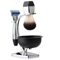 Chrome shaving set featuring a razor, a soft-bristle brush, and a black bowl on a matching metallic stand.