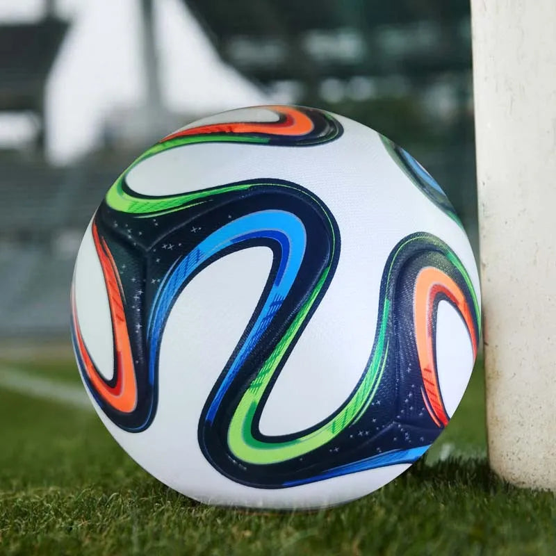 White football with vibrant blue, green, and orange swirl patterns, resting on grass against a goalpost.