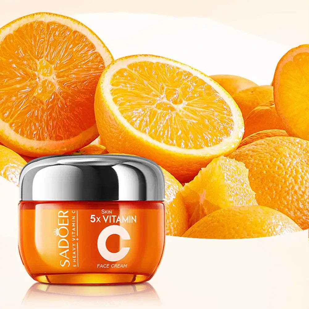 Vitamin C face cream in a round orange jar with a silver lid, set against a background of fresh sliced oranges.