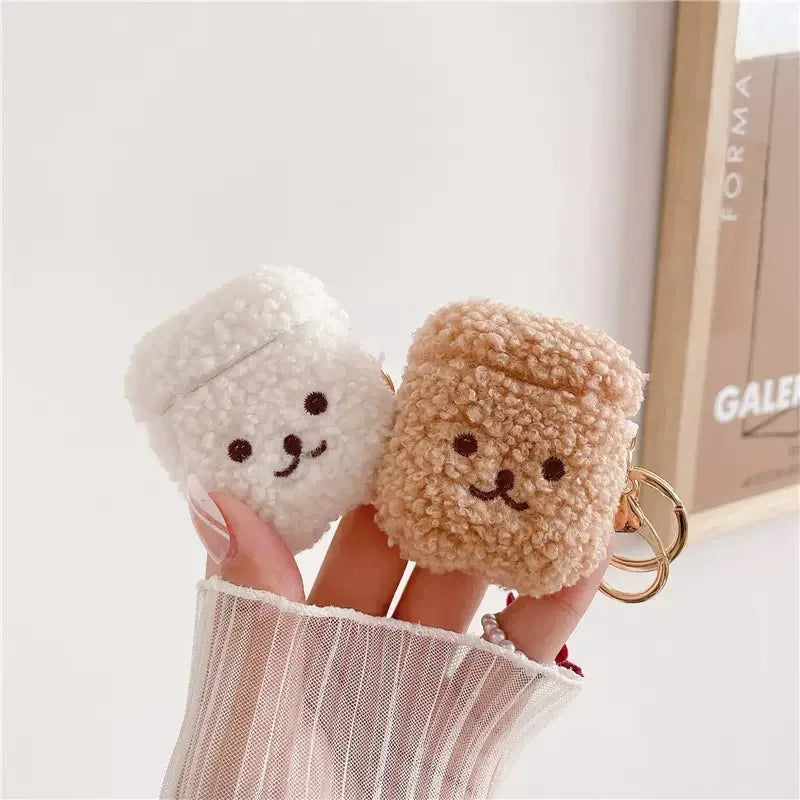 Cream and brown fluffy bear-style AirPods cases with keyrings, made from plush fabric.