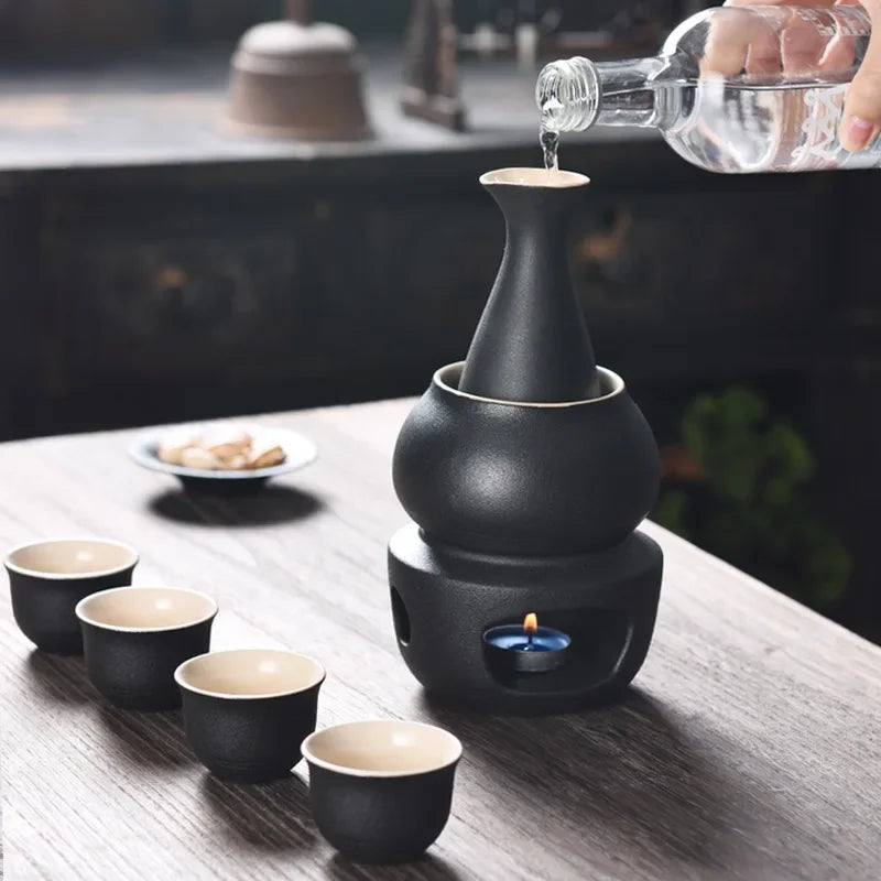 Matte black ceramic sake set with bottle, warmer cup, candle stove, and four matching cups.