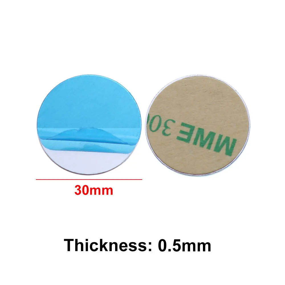 Two 30mm round adhesive metal plates; one shows the blue peel-off backing, the other the brown adhesive side.