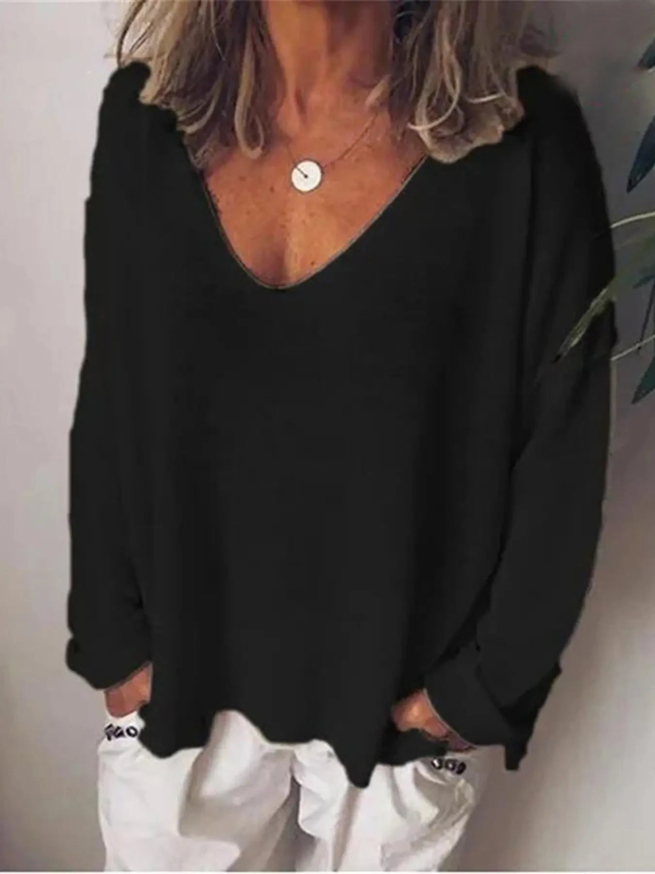 Women's black long-sleeve jumper with a deep V-neck and relaxed, oversized fit.