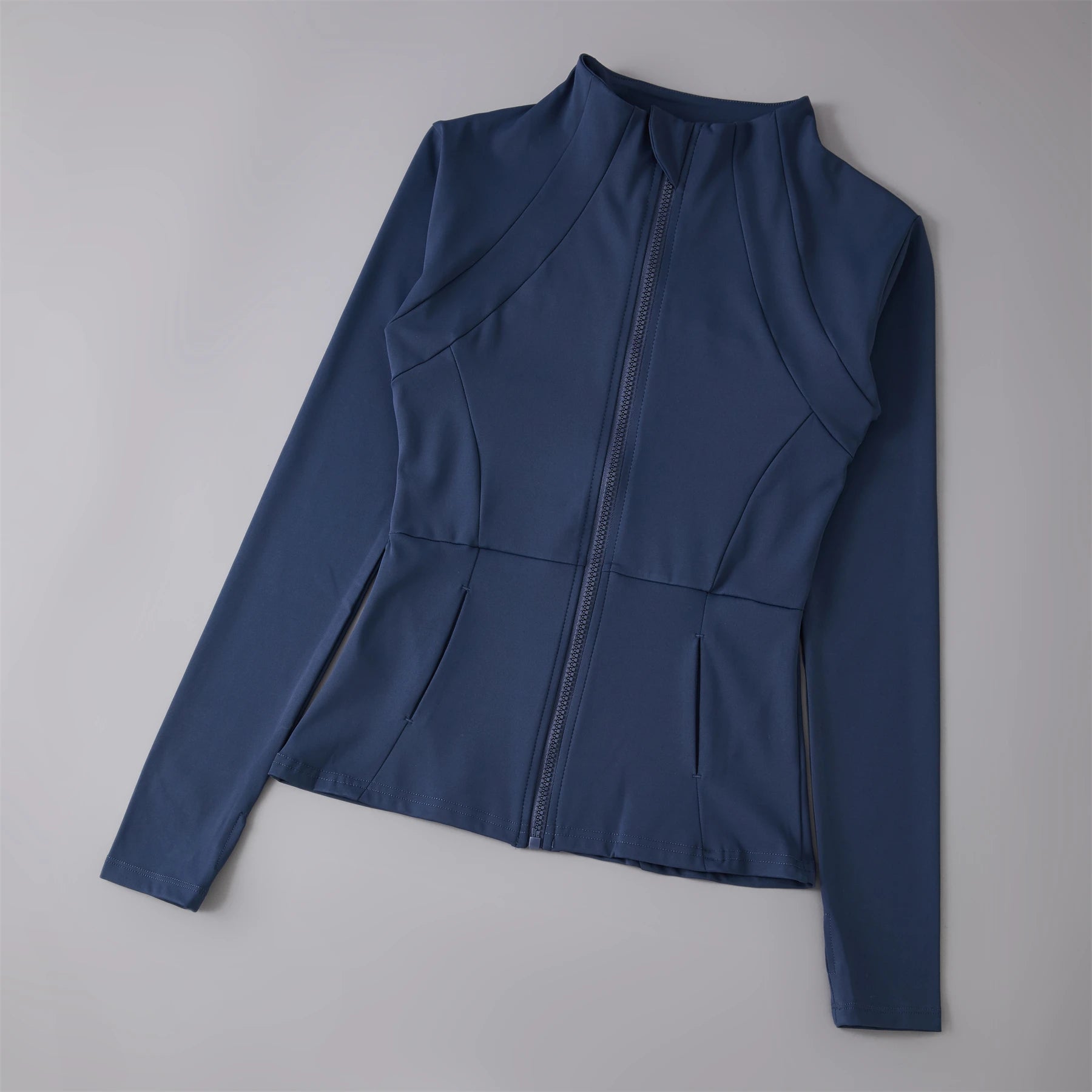 Navy blue fitted zip-up athletic jacket with high neck, long sleeves, and paneled seam detailing.
