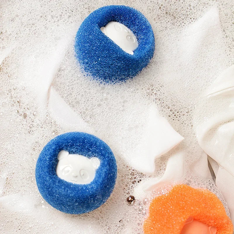 Two round, bright blue scrubbers featuring white panda face inserts, resting in bubbly soapy water.