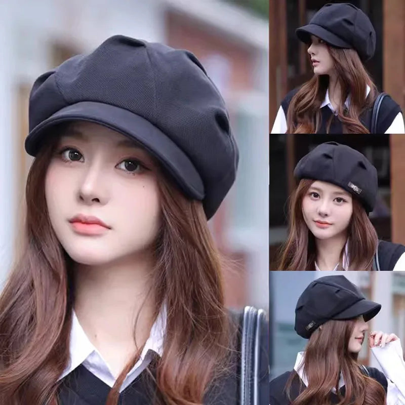Model wearing a black, retro-style newsboy beret with a structured brim and soft, multi-panelled crown.