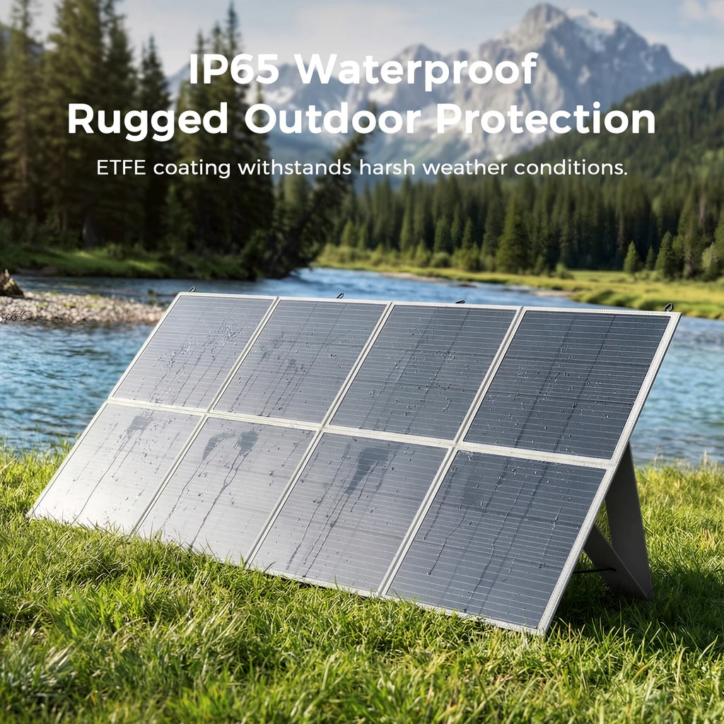 An eight-panel foldable solar panel is set up in a grassy field near a river, with mountains in the background.