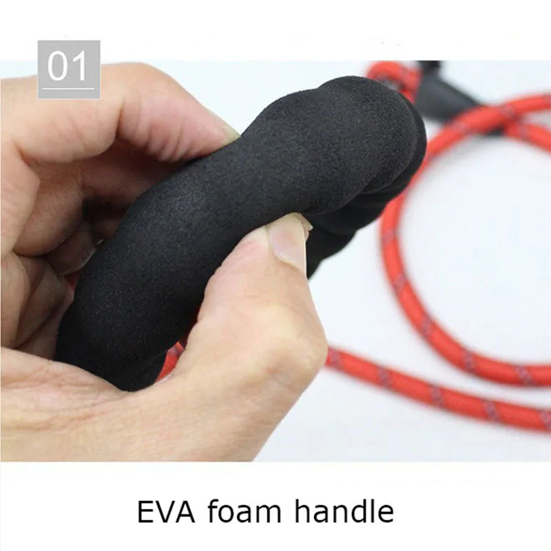 Close-up of a hand squeezing a soft, black EVA foam handle attached to a red reflective heavy-duty dog leash.