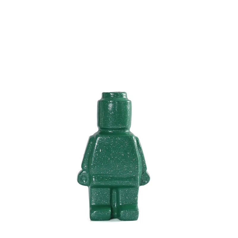 Dark green, speckled ceramic ornament shaped like a toy figure with a smooth, glossy finish.