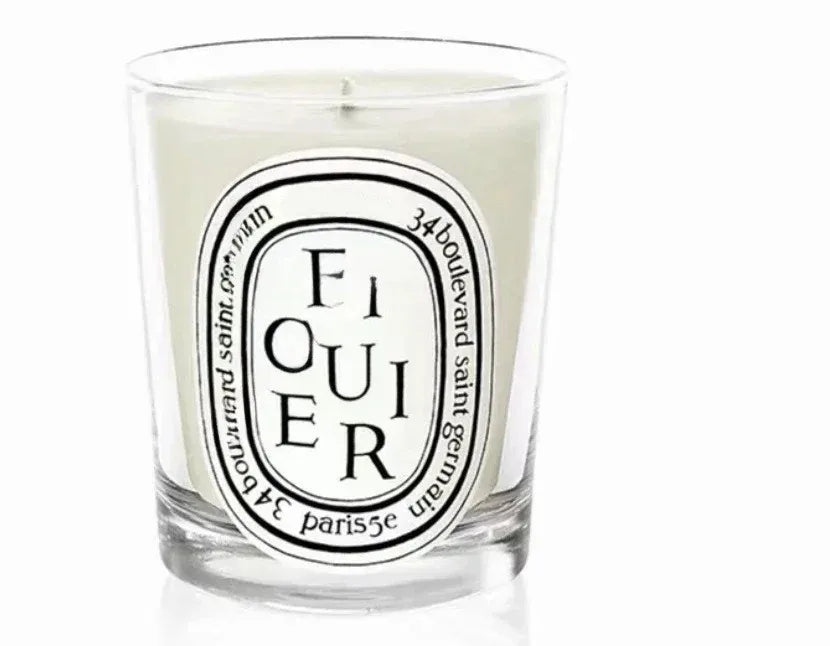 Scented candle in a clear glass jar featuring a classic oval white label with black elegant typography.