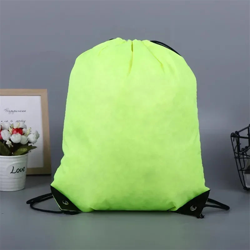 A neon yellow drawstring bag with black cord straps and reinforced black corners, set against a grey background.
