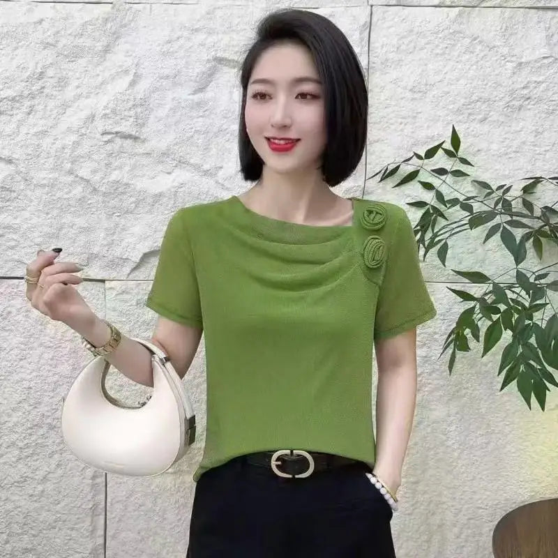 Apple green short-sleeved top with draped neckline, floral shoulder detail, and lightweight textured fabric.