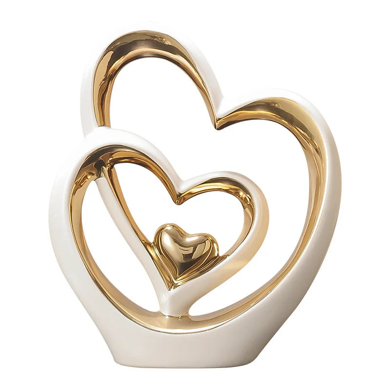 Minimalist ceramic decor featuring a white and gold abstract interlocking heart design.