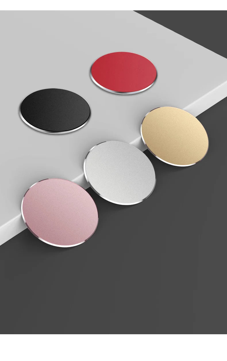 Five round, flat metal adhesive discs in red, black, gold, silver, and pink arranged on a tiered surface.