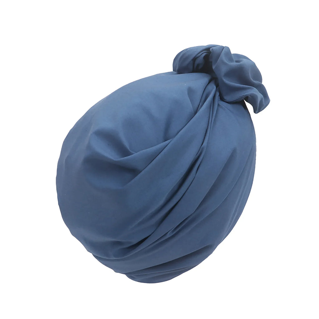 A vintage-style blue turban hat with elegant fabric folds and a decorative knot detail on the side.