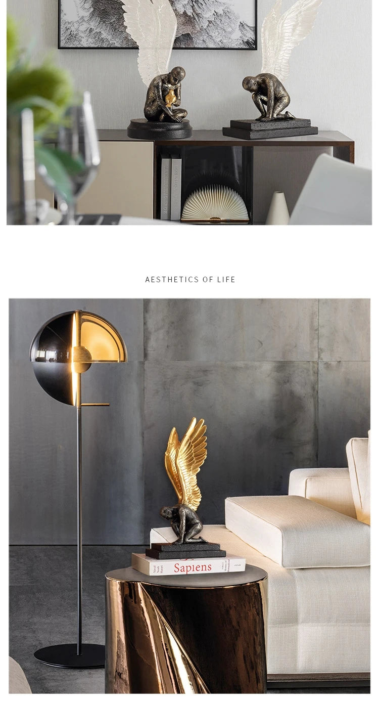 Decorative bronze-effect winged angel figurine with gold wings, sitting on a black base, displayed in a modern interior.