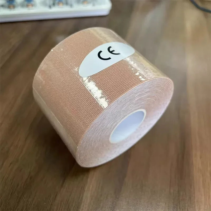 A roll of beige kinesiology tape wrapped in clear film with a white 'CE' sticker on a wooden surface.