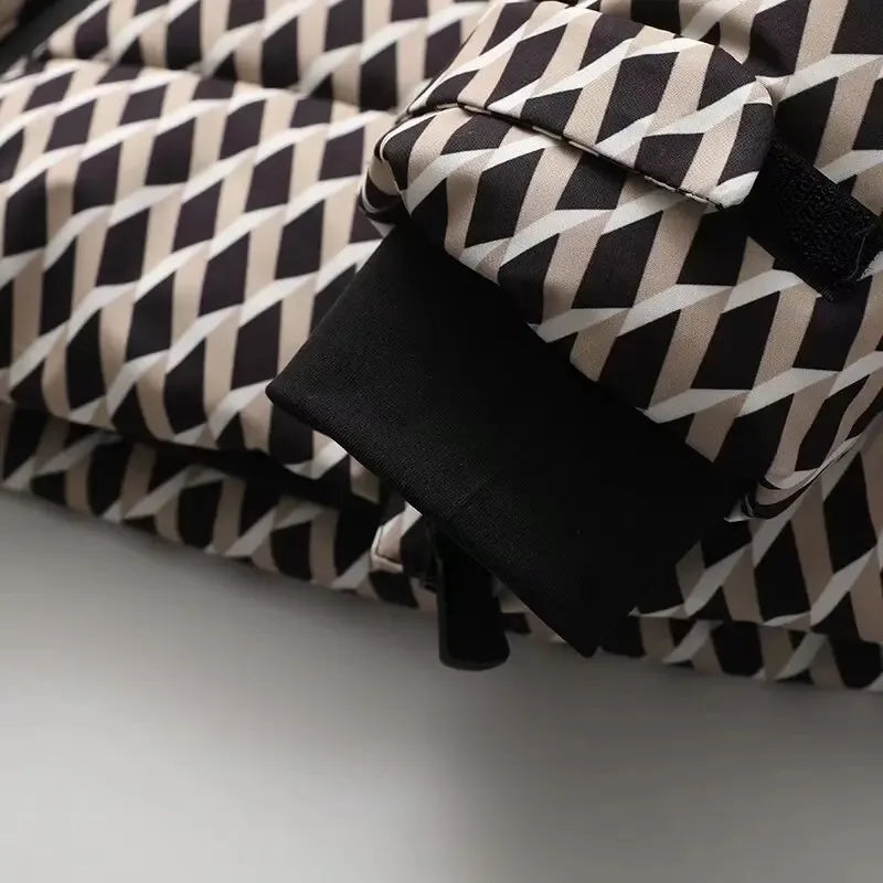 Close-up of a puffer jacket sleeve with a black, beige, and white geometric pattern and black ribbed cuff.