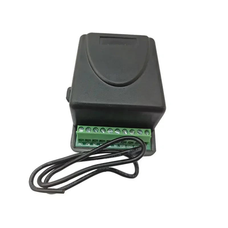 Black plastic electronic control box with a green terminal block for wiring connections and attached black cables.
